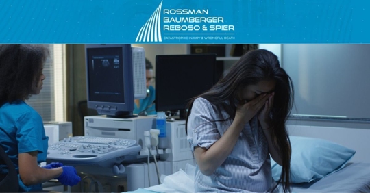 Woman in hospital crying with tech in the background